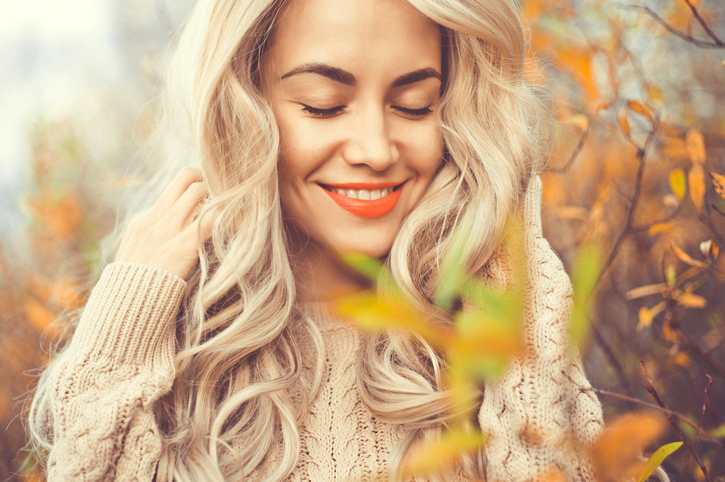 Beautiful lady surrounded autumn leaves