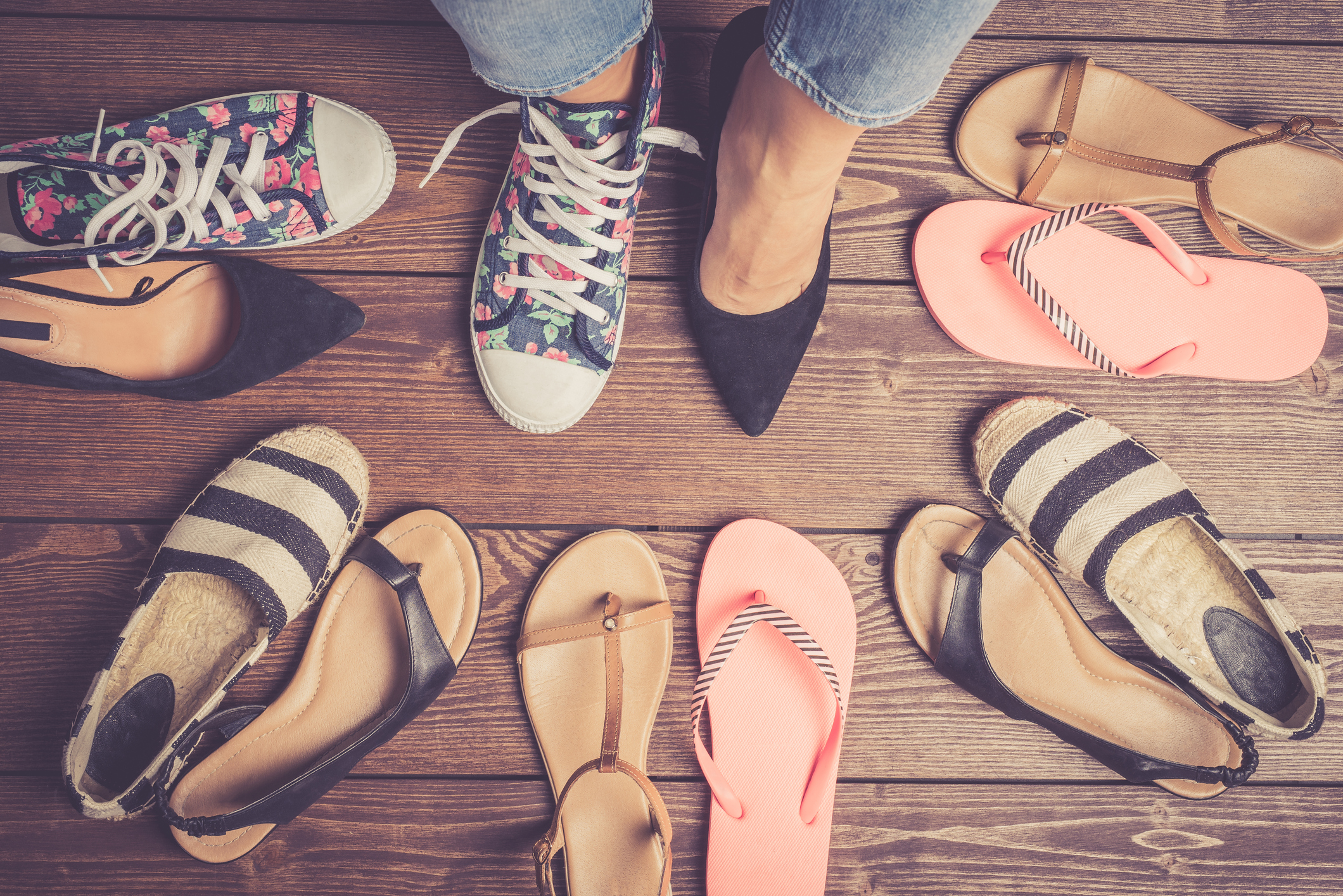 Collection of female shoes on wooden floor.