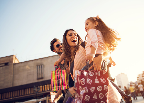 Low angle view of cheerful family having fun during a shopping day in the city.