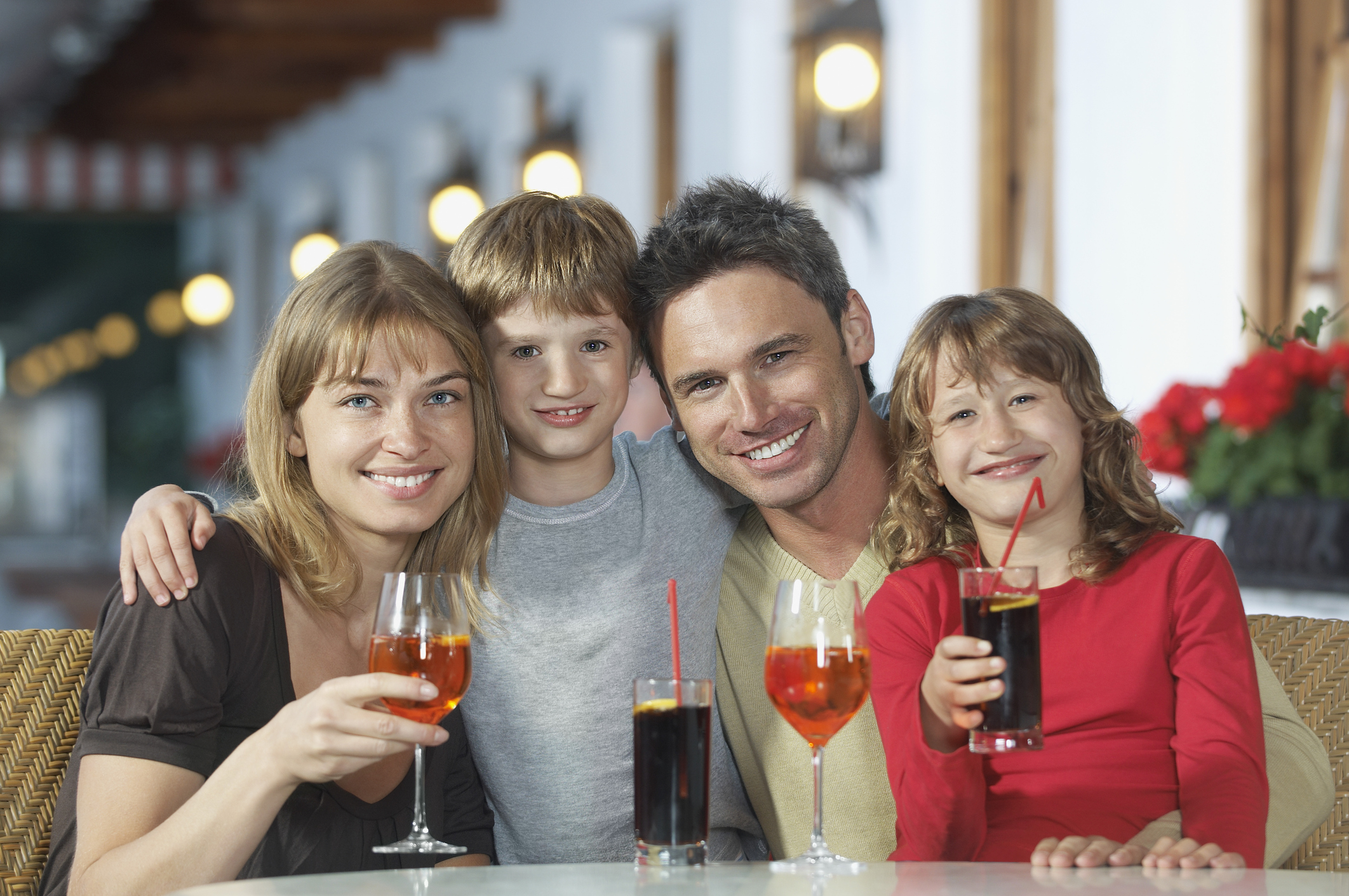 Parents and children (7-9) with drinks at restaurant portrait