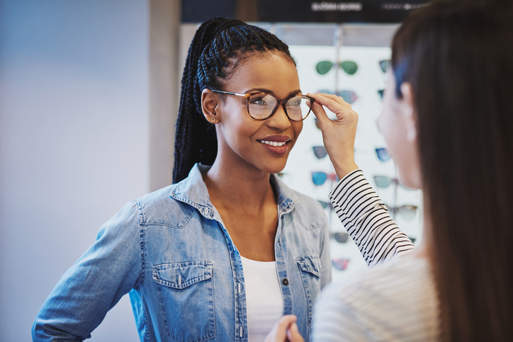 Optometrist fitting glasses on a customer