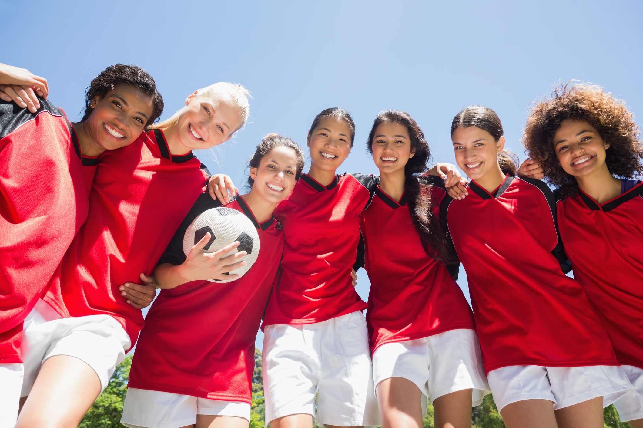 Female soccer team against clear blue sky